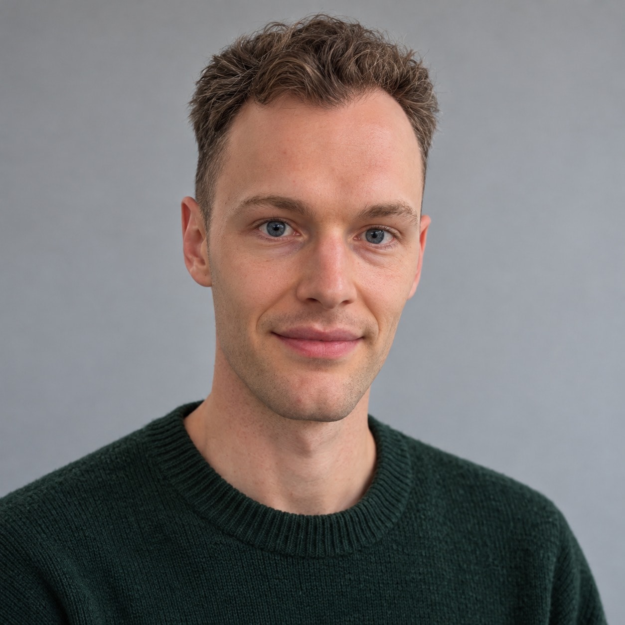 Kai Hatchman in a dark green jumper against a grey background
